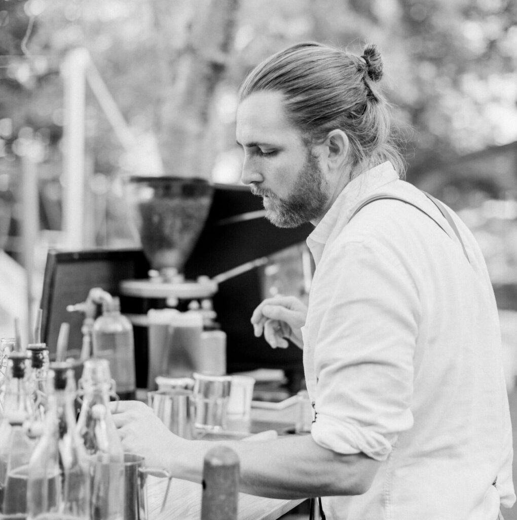 A skilled barista preparing artisan coffee with professional equipment and ingredients, offering a personalized coffee experience for events.